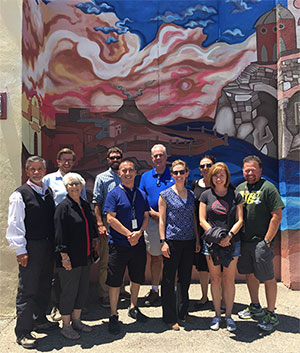 Team posing with mural