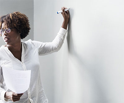 Woman writing on grease board